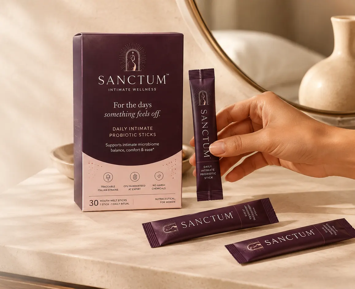 Hand holding a Sanctum Daily mouth-melt stick beside the box on a marble vanity